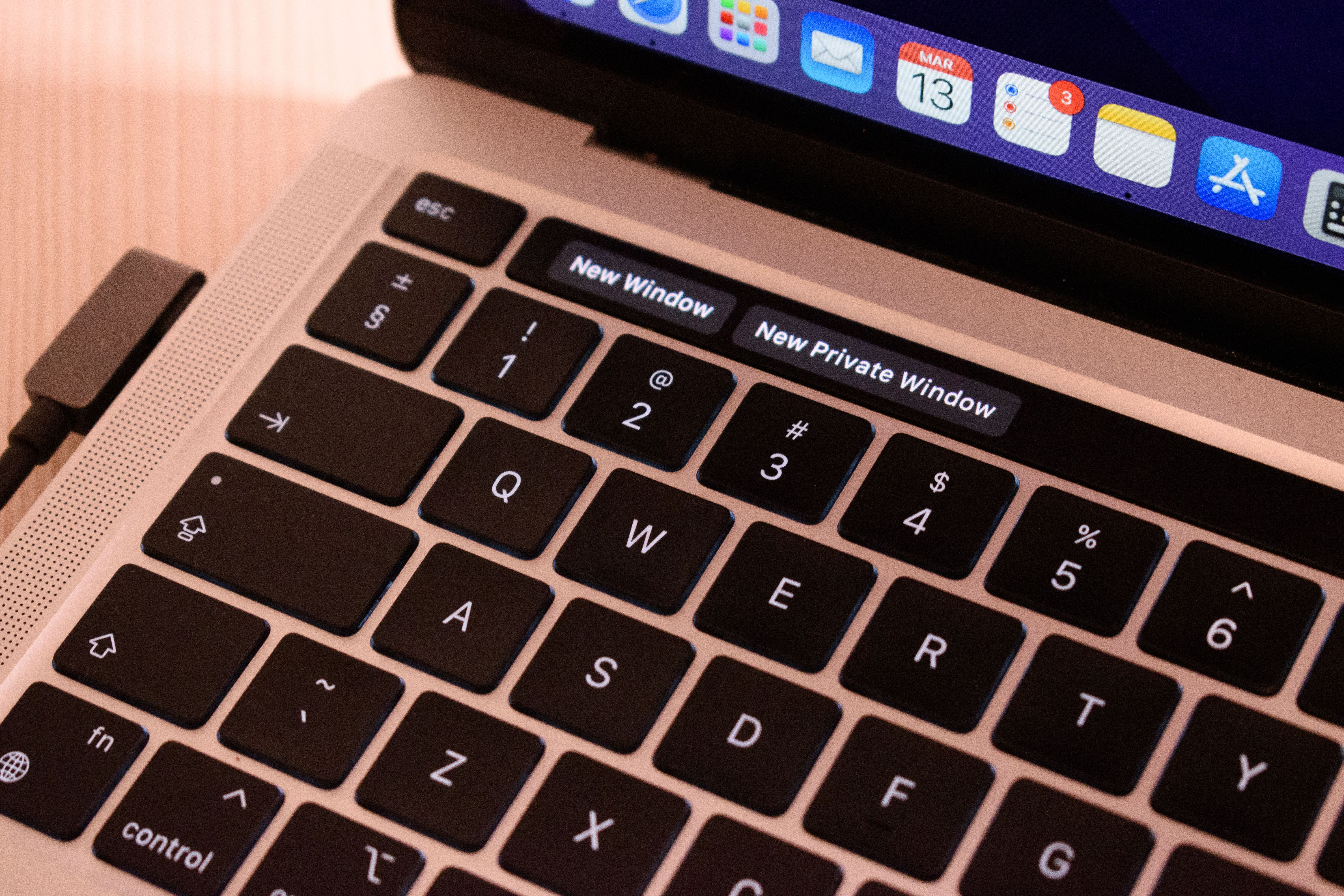 A detailed view of a laptop keyboard with browser tabs open, highlighting 'New Window' and 'New Private Window'.