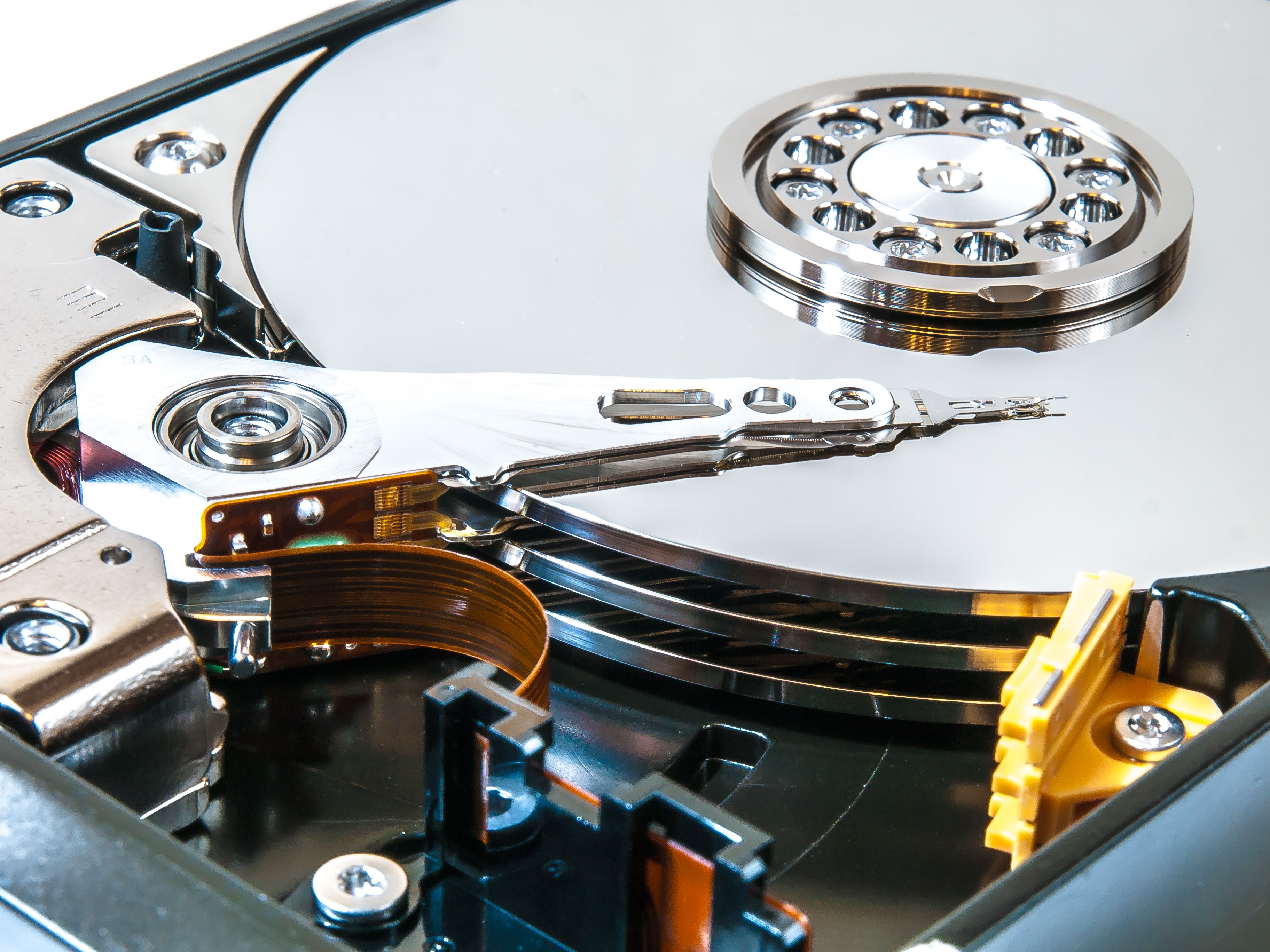Detailed view of an open hard drive showing its internal mechanisms and disk platters.
