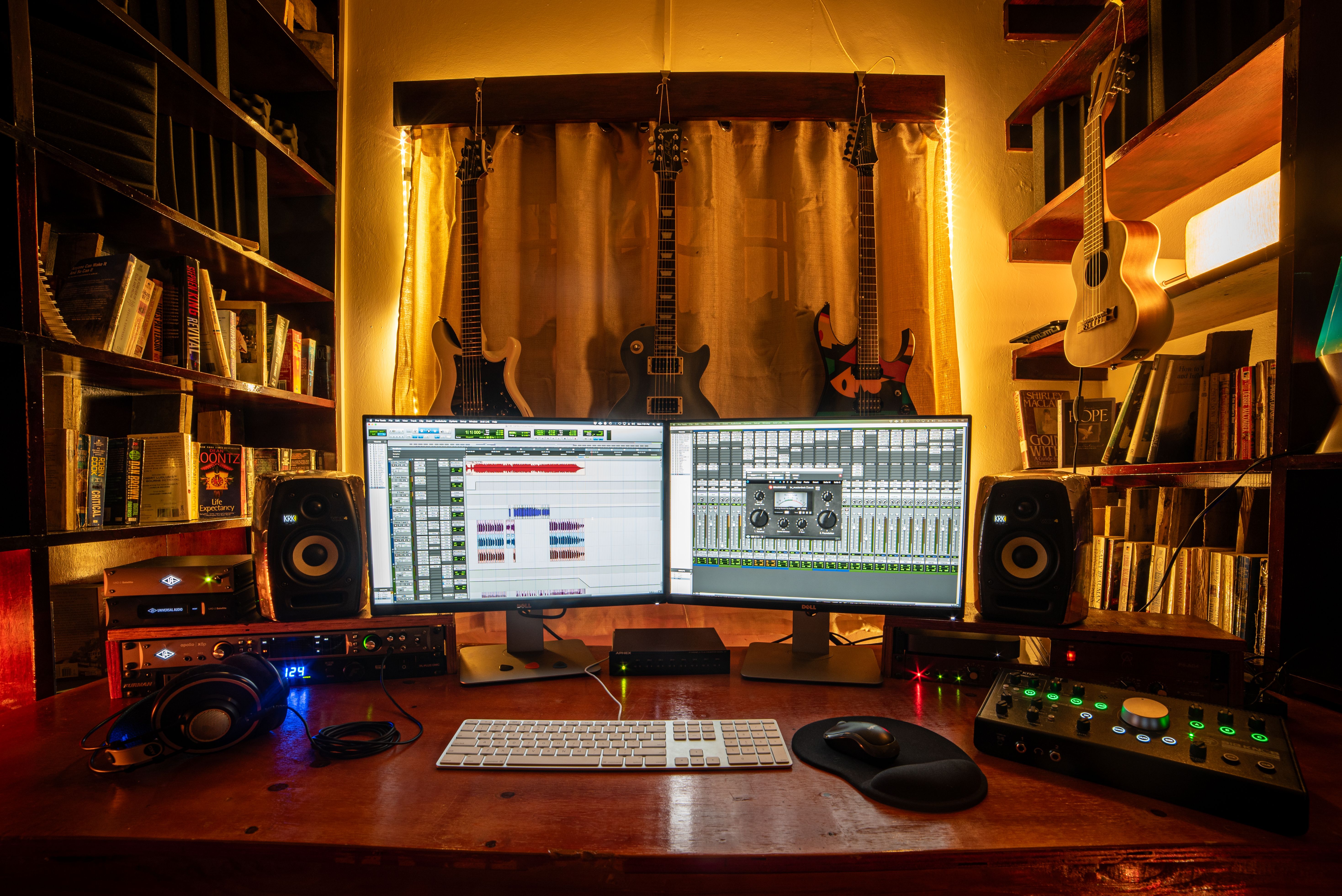 A well-equipped home music studio with guitars, monitors, and recording software in Trinidad and Tobago.