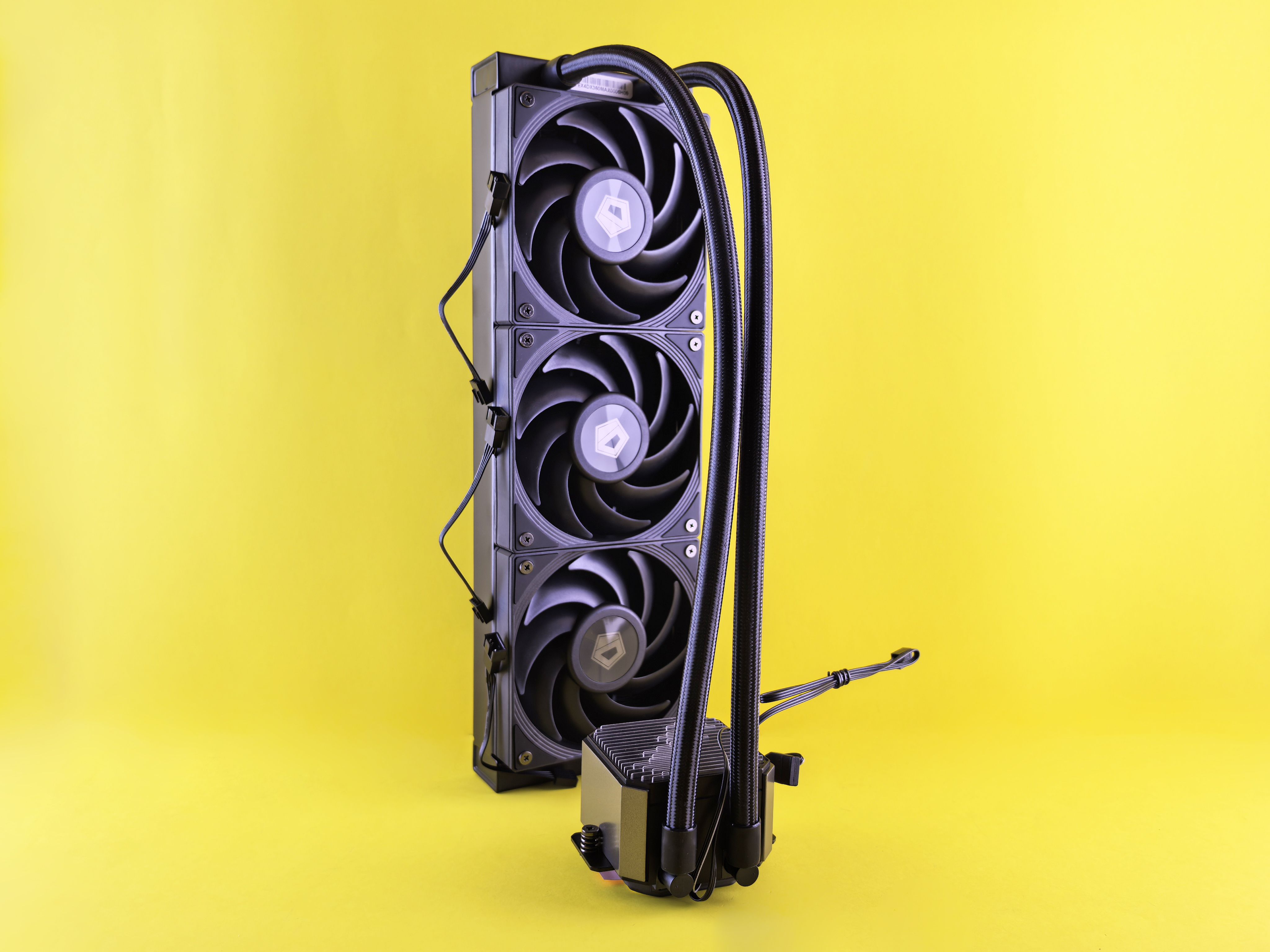Close-up of a modern CPU cooler with triple fans against a vibrant yellow backdrop, ideal for tech blogs and reviews.