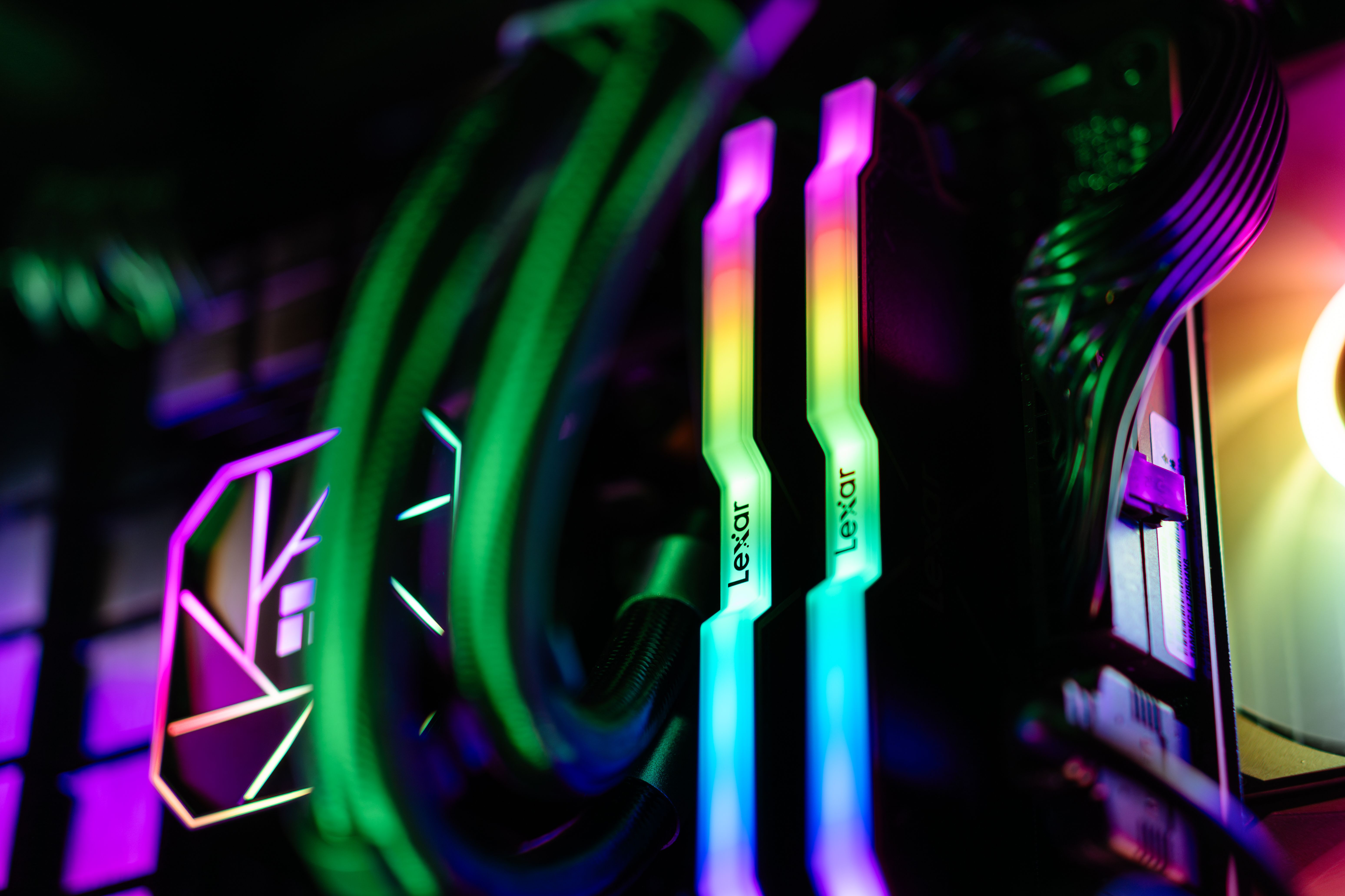 Close-up of colorful RGB illuminated PC components showcasing RAM and cooling system.