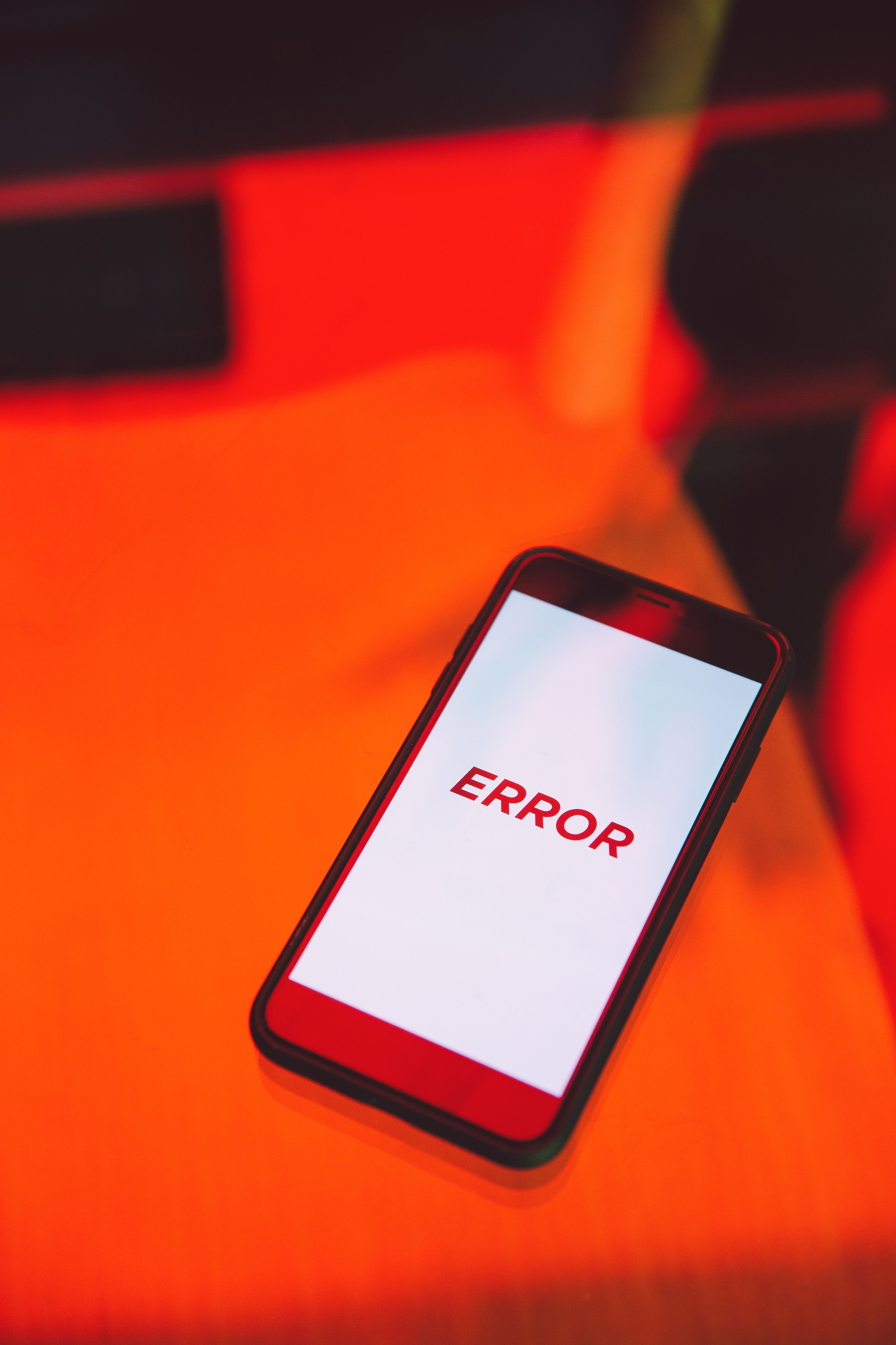 Smartphone displaying an error message on a vibrant red surface.