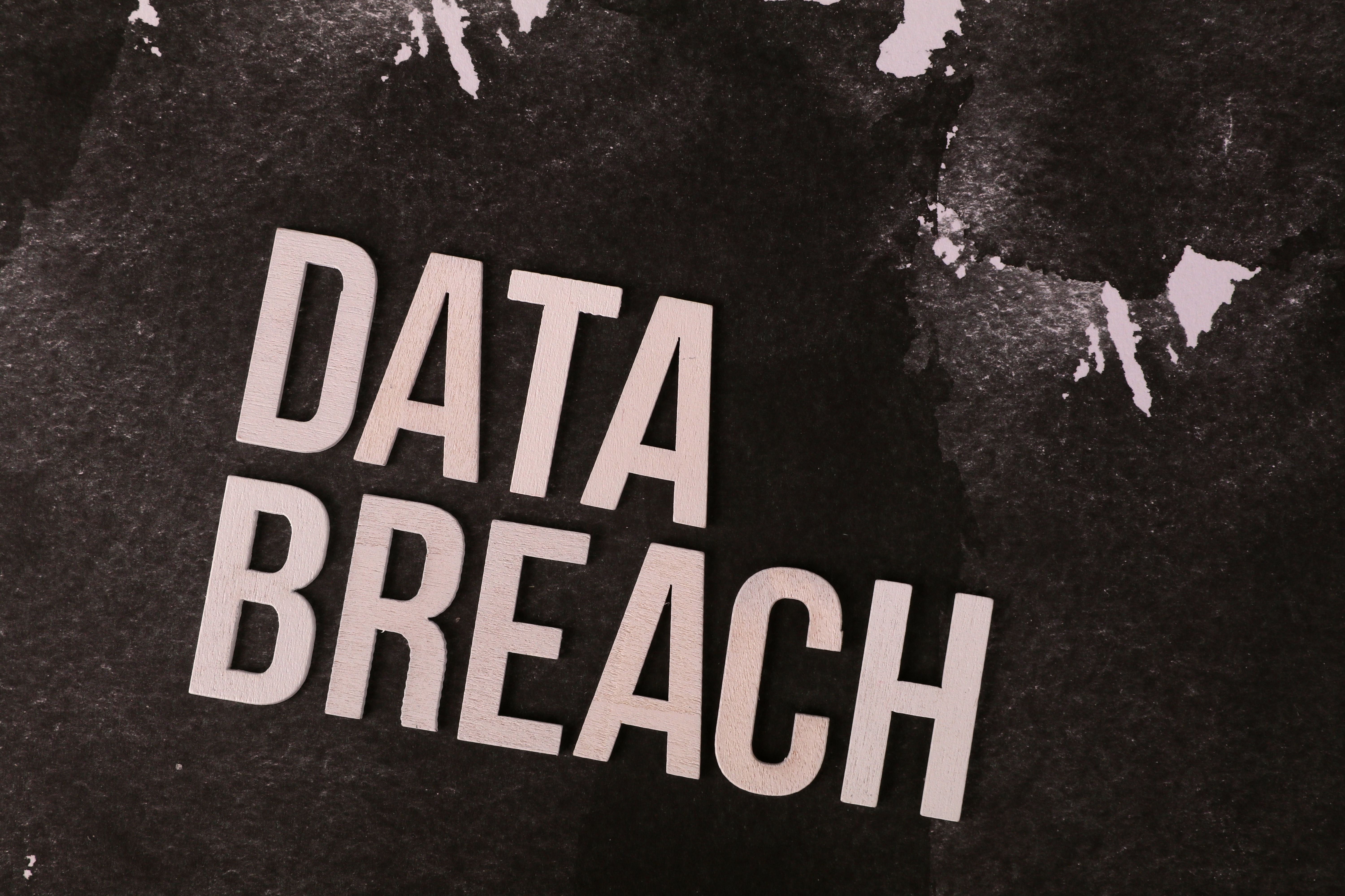 A conceptual image highlighting the issue of data breaches, featuring bold text on a textured background.