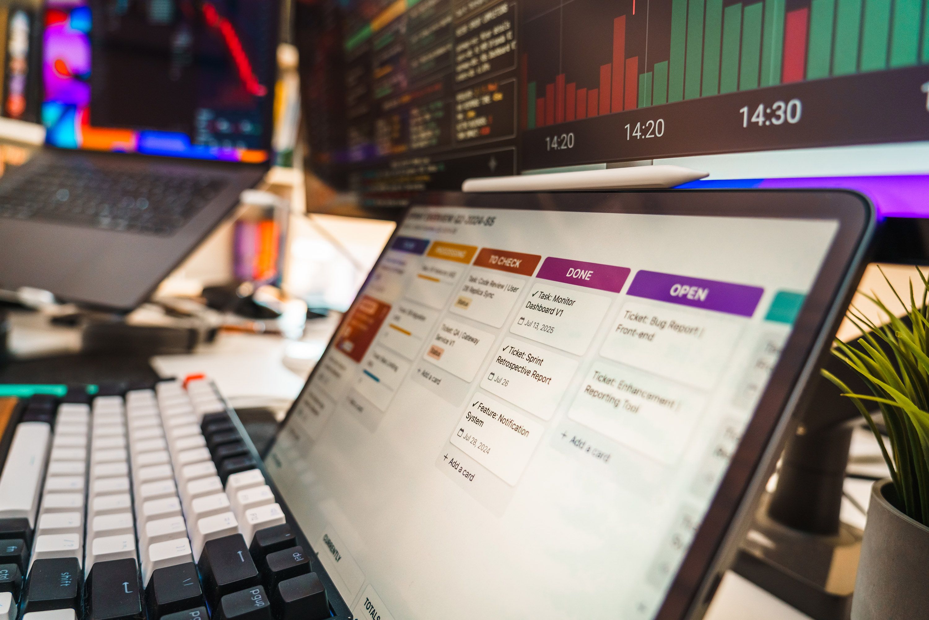 A dynamic office setup featuring multi-screen displays with data charts and project management tools, perfect for tech or business environments.