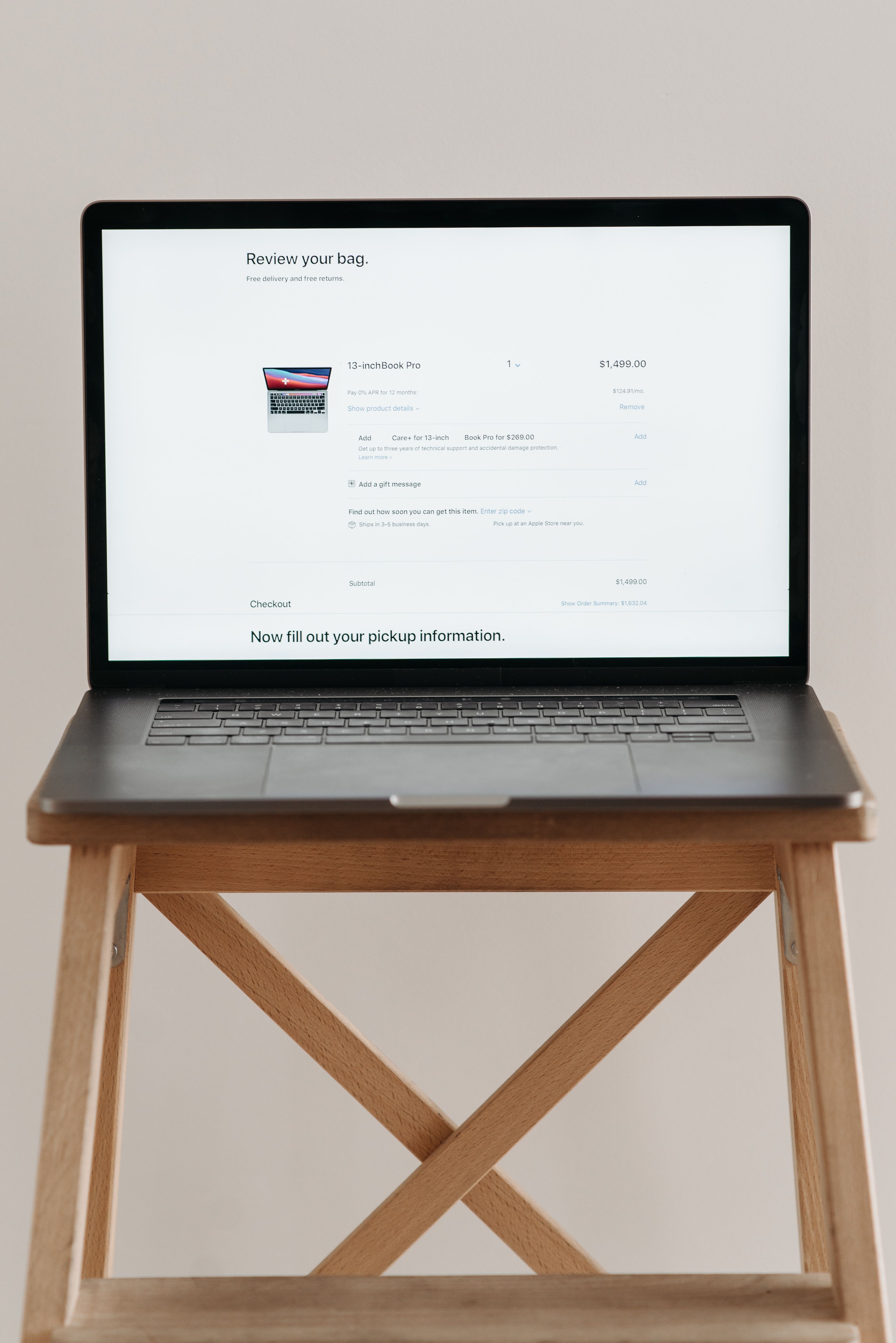Open laptop displaying checkout screen on a wooden stand, ideal for e-commerce themes.